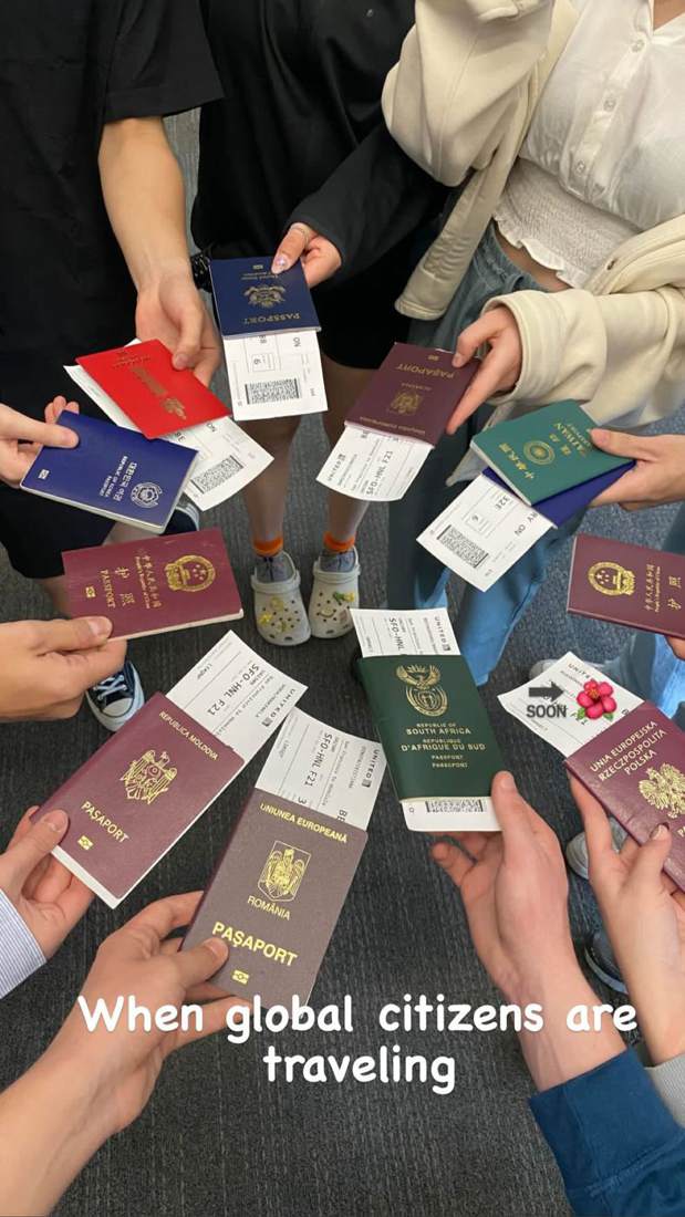 A circle of hands holding passports from many countries