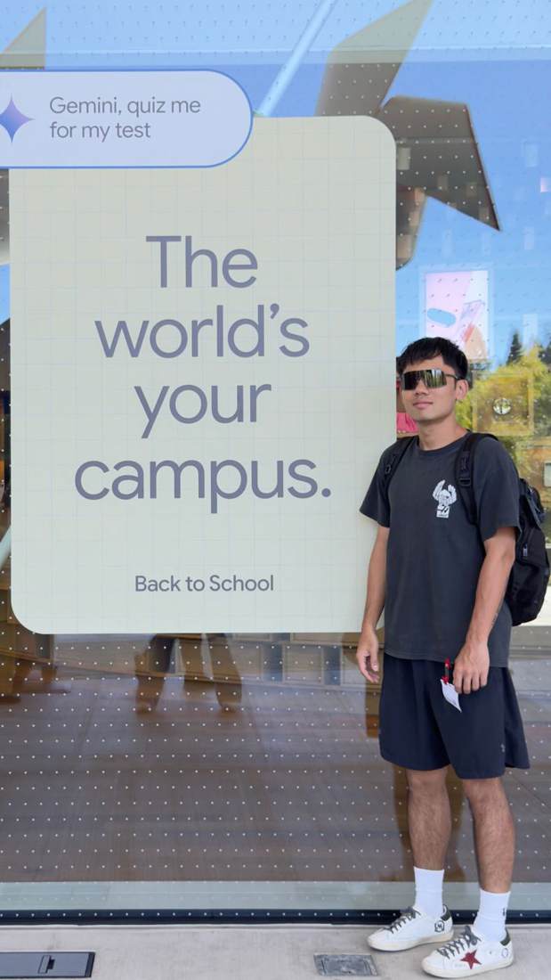 Dexter in front of a sign that reads The world's your campus